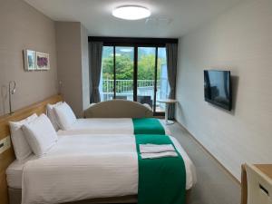 a hotel room with a bed and a television at Hatago Nagomi in Nikko