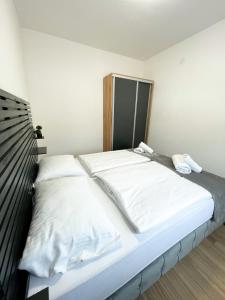 a bed in a room with white sheets and pillows at Tijana 2 in Pale