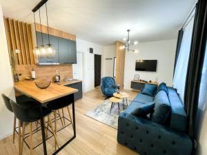 a living room with a blue couch and a kitchen at Tijana 2 in Pale