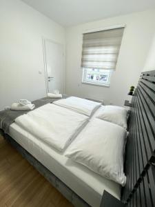 a large white bed in a white room with a window at Tijana 2 in Pale
