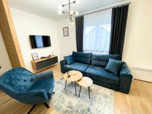 a living room with a blue couch and a chair at Tijana 2 in Pale