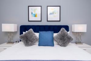 un letto con testata blu e due lampade di Gorgeous 4 Bedroom Family Friendly Close to Disney 7573 a Orlando