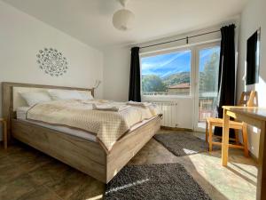 1 dormitorio con cama y ventana grande en Bebalkan guesthouse en Raduil