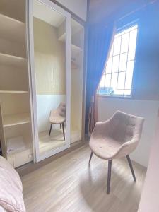 a bedroom with a chair in front of a mirror at Apartemen Pakubuwono Terrace Tipe Studio Jakarta in Jakarta