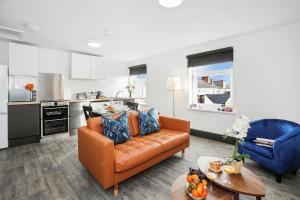 a living room with a couch and a kitchen at TYME Coastal Suites-1 and 2 Bedroom in Cleethorpes