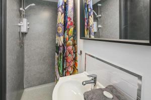 a bathroom with a sink and a shower curtain at TYME Coastal Suites-1 and 2 Bedroom in Cleethorpes