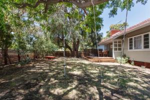 einen Hof mit einer Schaukel vor einem Haus in der Unterkunft Home Away - 2 Bedroom Cottage in Bicton