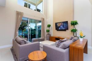 uma sala de estar com dois sofás e uma televisão em Stunning 4Bd Close to Disney @ Magic Village 7614 em Orlando