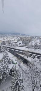 a snow covered city with a road and trees at Casa Lazăr in Braşov
