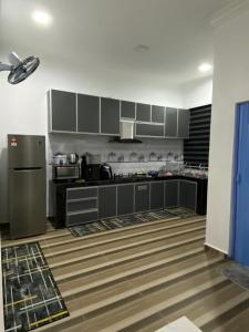 a kitchen with gray cabinets and a refrigerator at JRK HOMESTAY A in Jertih