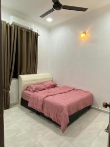 a bedroom with a bed and a ceiling fan at JRK HOMESTAY A in Jertih