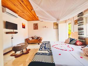 a bedroom with a bed and a couch in a room at Régina Lodge Diégo Suarez Madagascar in Diego Suarez