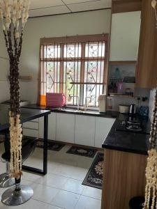 a kitchen with a table and a window in it at T'Rai Homestay in Dungun