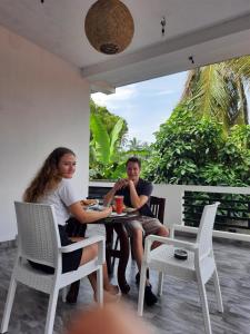 a man and a woman sitting at a table at Villa Freiheit Himmel in Bentota