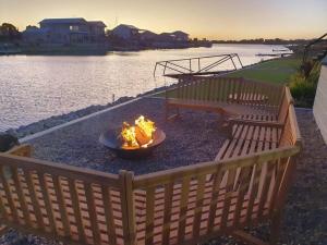 a fire pit on a patio next to a body of water at Olley's Place in Wellington East