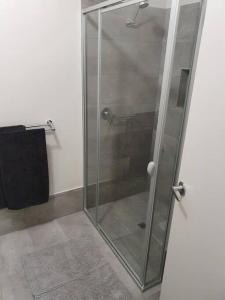 a shower stall with a glass door in a bathroom at Olley's Place in Wellington East