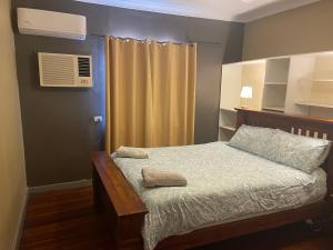a bedroom with a bed and a air conditioner at Central on Shenton in Geraldton