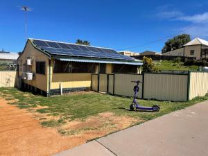 a scooter parked in front of a house with solar panels at Central on Shenton in Geraldton