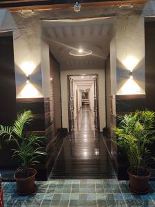 a hallway with potted plants in a building at Kamadhenu Residency Homestay & Service Apartment Coorg Madikeri in Madikeri