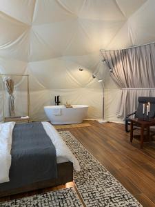 a bedroom with a tub in a tent at Bidiyah Domes in Bidiyah