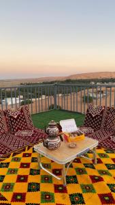 a coffee table on a balcony with a view of the ocean at Bidiyah Domes in Bidiyah
