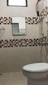 bagno con servizi igienici e specchio di Royal Stay@Yogyakarta a Kalasan