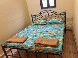 ein Bett mit blauer Bettdecke und zwei Handtüchern darauf in der Unterkunft Ashpil House Guest House Margao South Goa in Navelim