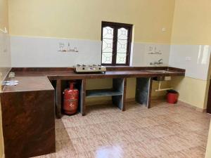 Zimmer mit einem Holztisch und einem Fenster in der Unterkunft Ashpil House Guest House Margao South Goa in Navelim