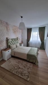 a bedroom with a bed and a large window at Central Residence in Bacău