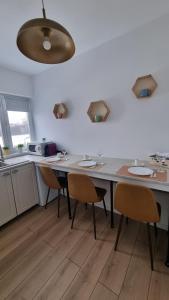 a kitchen with a table with chairs and a counter at Central Residence in Bacău