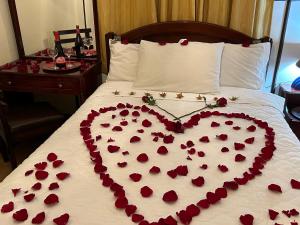 a heart made out of red roses on a bed at Casa Franciscana in Quito