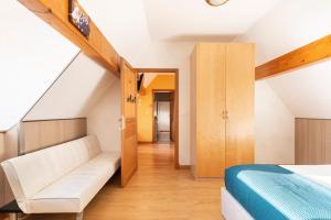een kamer met een bed, een bank en een trap bij Les Grands Crus - Meursault in Corpeau