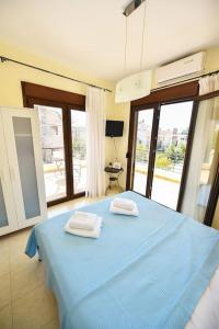 a bedroom with a blue bed with two towels on it at Guedin Sea Side Maisonette, Nikiti in Nikiti