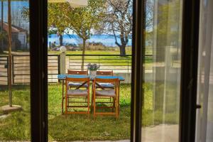 stół i krzesło siedzące na zewnątrz okna w obiekcie Guedin Sea Side Maisonette, Nikiti w mieście Nikiti
