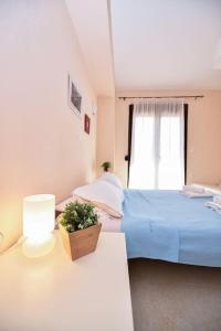 um quarto com uma cama azul e uma janela em Guedin Sea Side Maisonette, Nikiti em Nikiti