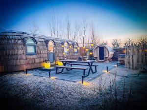 a patio with a picnic table in front of a building at Bed & Wellness Klein Knorrestein with 2 romantic sustainable tiny house, use private hottub, sauna, tandembike included in price, just 30 minutes from Amsterdam in Almere