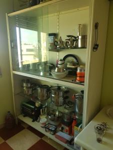 a cabinet filled with lots of pots and pans at Appartement Tona in Bouselama