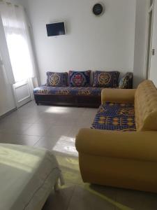a living room with a couch and a tv at Appartement Tona in Bouselama