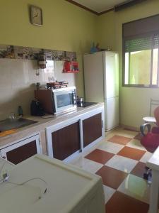 a kitchen with a microwave and a counter top at Appartement Tona in Bouselama