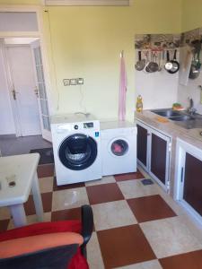 a kitchen with a washing machine in a kitchen at Appartement Tona in Bouselama +10 photos