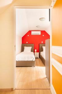een slaapkamer met 2 bedden en een rode muur bij Les Grands Crus - Pommard in Corpeau