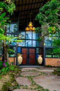 - un bâtiment avec une porte rouge et un lustre dans l'établissement Khwaithai Resort & Homestay - ควายไทย, 