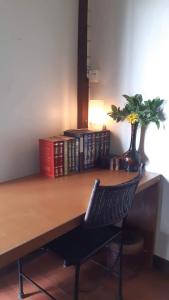 un escritorio con una silla y un jarrón con una planta en The North Hotel, en Chiang Rai