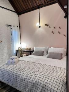 a bedroom with a large white bed and a desk at Hugs Home & Cafe Trang in Trang