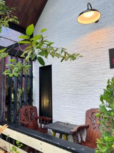 a patio with two chairs and a table at Hugs Home & Cafe Trang in Trang