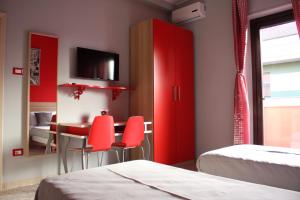 a room with red cabinets and a table and chairs at Bed & Breakfast La Perla Rosa in Pescara