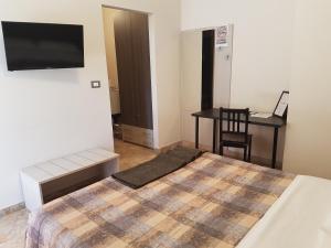 a bedroom with a bed and a desk and a television at B&B Monté in Montesilvano