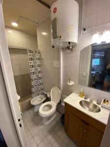 y baño con aseo, lavabo y espejo. en Dpto panorámico chic microcentro en Mendoza