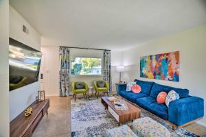 a living room with a blue couch and a table at Spacious Riverside Home with Game Room and Yard in Riverside