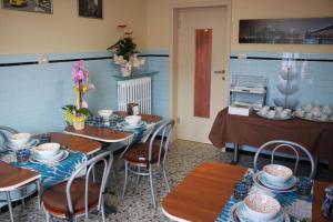 a dining room with tables and chairs with blue walls at Bed & Breakfast La Perla Rosa in Pescara